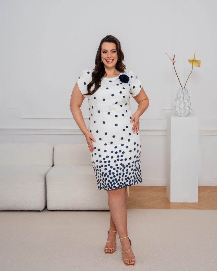 Biała sukienka ołówkowa plus size w granatowe grochy, zagęszczające się ku dołowi, z ozdobnym kwiatem
